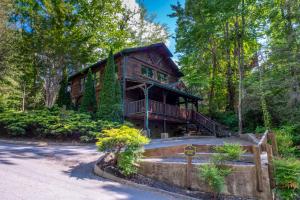 a large log cabin in the woods with a driveway at Evening Star in Gatlinburg