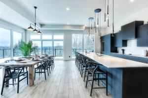 a kitchen with a long dining table and chairs at Tremblant Summit: Travel Experience Beyond Compare in La Conception