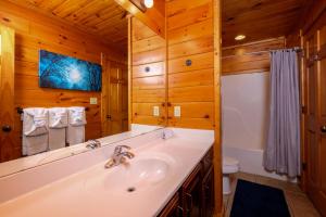 a bathroom with a tub and a sink at Evening Star in Gatlinburg +35 photos