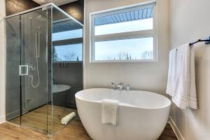a white bath tub in a bathroom with a window at Tremblant Summit: Travel Experience Beyond Compare in La Conception +41 photos