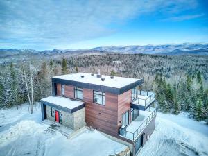 a house on top of a snow covered mountain at Tremblant Summit: Travel Experience Beyond Compare in La Conception