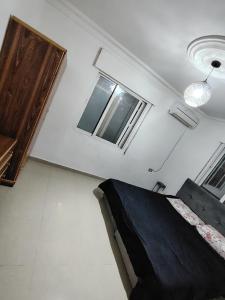 ein Schlafzimmer mit einem Bett und zwei Fenstern in der Unterkunft شقة ريماس in Irbid