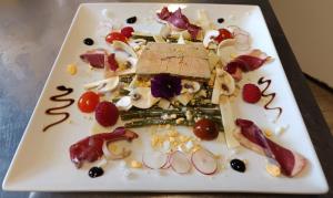 a white plate of food on a table at Logis Hotel Restaurant La Chaumière in Tournon-sur-Rhône