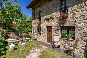 a stone house with a table and chairs in front of it at Casa Engracita in Valle de Lago