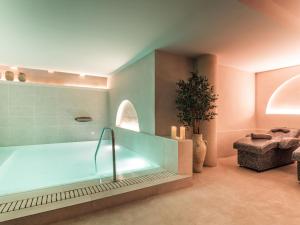 a bathroom with a bath tub in a room at Hotel Well and Come Málaga in Málaga