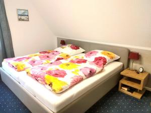 a bedroom with a bed with a flower blanket and pillows at Sommerwind in Eutin