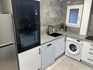a kitchen with a microwave and a washer and dryer at Cal Botey in Ripoll
