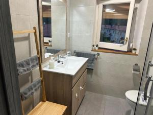 a bathroom with a sink and a toilet and a mirror at Cal Botey in Ripoll +4 photos