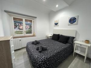 a bedroom with a bed and two tables and a window at Cal Botey in Ripoll