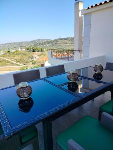 a balcony with a blue table and chairs and a view at Serenity Horizon Villa in Theologos