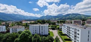 a city with buildings and mountains in the background at La vue Appartement Gruyère in Bulle