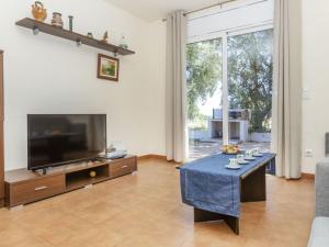 a living room with a flat screen tv and a table at Holiday Home Bretos by Interhome in Fonts