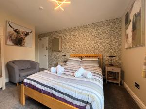 a bedroom with a bed and a chair at Winmar Guesthouse in Inverness