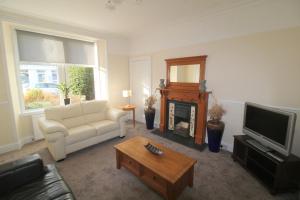 a living room with a white couch and a tv at Winmar Guesthouse in Inverness