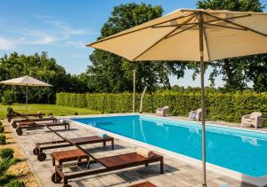 a swimming pool with benches and an umbrella at Moslavačka Priča Holiday Homes in Mala Ludina +124 photos