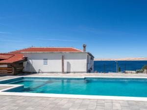 a swimming pool in front of a house with the ocean at Apartment Delfin-10 by Interhome in Cesarica +32 photos