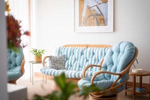 a living room with a blue couch and two chairs at Casa da Maresia - The Seaside Escape in Paul do Mar