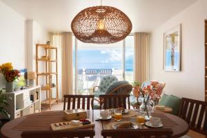 a living room with a table and a large window at Casa da Maresia - The Seaside Escape in Paul do Mar +20 photos