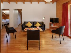 a living room with a couch and chairs and a table at Apartment Chalet Almisgässli by Interhome in Grindelwald