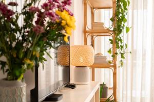 a tv sitting on a table with vases of flowers at Casa da Maresia - The Seaside Escape in Paul do Mar