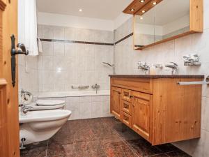 a bathroom with a sink and a toilet and a tub at Apartment Chesa Dal Luf B5 by Interhome in Silvaplana