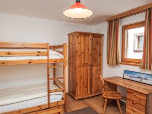 a bedroom with two bunk beds and a desk at Apartment Chesa Dal Luf B5 by Interhome in Silvaplana