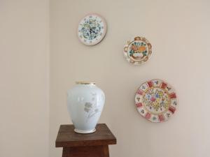 a vase on a wooden table with plates on a wall at Holiday Home Borowikowa by Interhome in Sasino