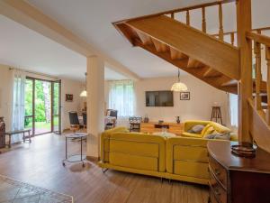 a living room with a yellow couch and wooden floors at Holiday Home Borowikowa by Interhome in Sasino