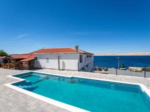 a swimming pool in front of a house at Apartment Delfin-4 by Interhome in Cesarica