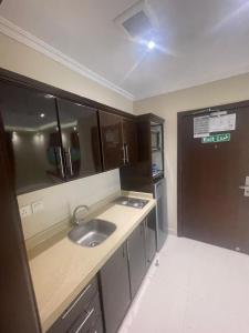 a small kitchen with a sink and a refrigerator at Al Muhaidb Residence Holiday Homes Al Hada Resort - Economic in Al Hada +64 photos