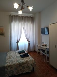 a bedroom with a bed and a table and a window at Il Papavero Nero in Rome
