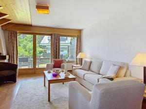 a living room with a couch and a table at Apartment Victoria C 8 by Interhome in Crans-Montana