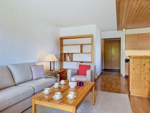 a living room with a couch and a coffee table at Apartment Victoria C 8 by Interhome in Crans-Montana +39 photos