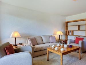 a living room with a couch and a table at Apartment Victoria C 8 by Interhome in Crans-Montana