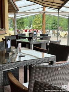 an outdoor dining area with tables and chairs and tablesktop at Parkhotel Waldbreitbach in Waldbreitbach