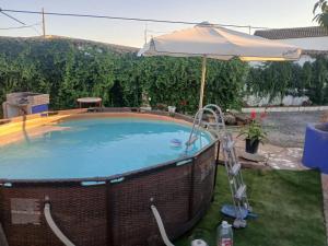 a large swimming pool with an umbrella and an umbrella at Casa El Filali in Villaminaya