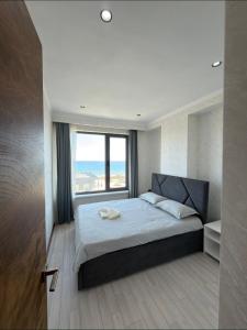 a bedroom with a large bed with a large window at Novel Hotel&Apartaments in Korumdy
