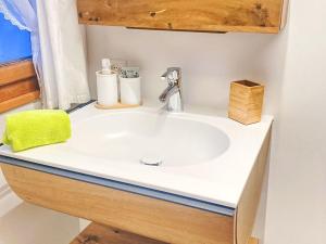 a bathroom with a white sink and a mirror at Apartment Scheftenau by Interhome in Wattwil