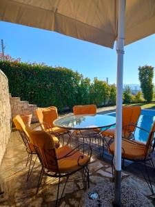 a patio with a table and chairs under an umbrella at Serenity Horizon Villa in Theologos