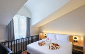a hotel room with a bed with a towel on it at The Dyastana Umalas in Kerobokan +29 photos