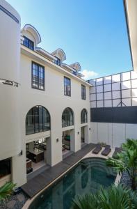 an exterior view of a building with a swimming pool at The Dyastana Umalas in Kerobokan