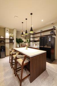 a kitchen with a large island with chairs and a counter at The Dyastana Umalas in Kerobokan