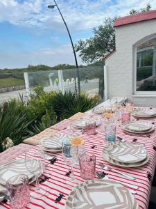 a table with plates and glasses on top at Strandvilla Zeegloed in Sint-Idesbald