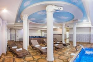 a room with a swimming pool and a ceiling at Cron Palace kosher Tbilisi Hotel in Tbilisi City