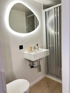 a bathroom with a white sink and a mirror at Strandvilla Zeegloed in Sint-Idesbald