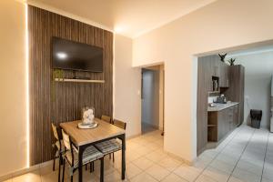 a dining room with a table and a television on a wall at Meerkat Manor Self-Catering & Accommodation Windhoek in Windhoek