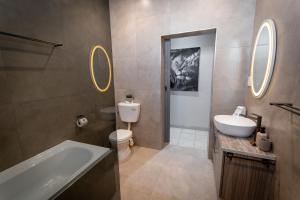 a bathroom with a tub and a toilet and a sink at Meerkat Manor Self-Catering & Accommodation Windhoek in Windhoek +33 photos