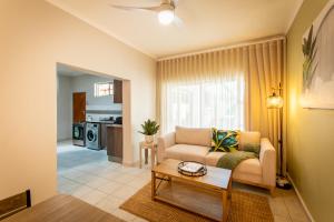 a living room with a couch and a table at Meerkat Manor Self-Catering & Accommodation Windhoek in Windhoek