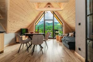 a room with a table and chairs and a large window at Apartamenty Premium VIEW JACUZZI & SAUNA in Kościelisko