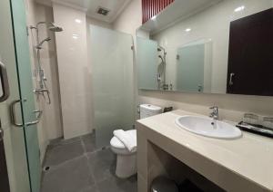 ein Badezimmer mit Waschbecken, Toilette und Dusche in der Unterkunft BBIB Suites in Wonorejo + 18 Fotos